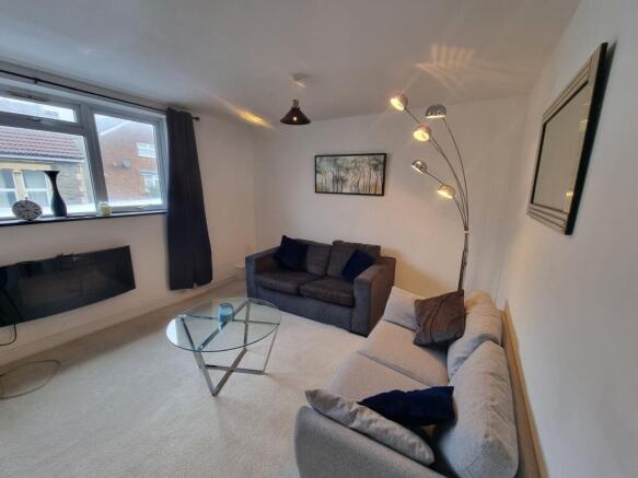 A bright and welcoming living room featuring tw...