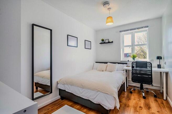 A bright and tidy double bedroom featuring a co...