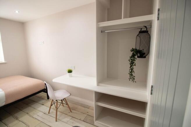 A bright, modern bedroom featuring a cozy bed w...