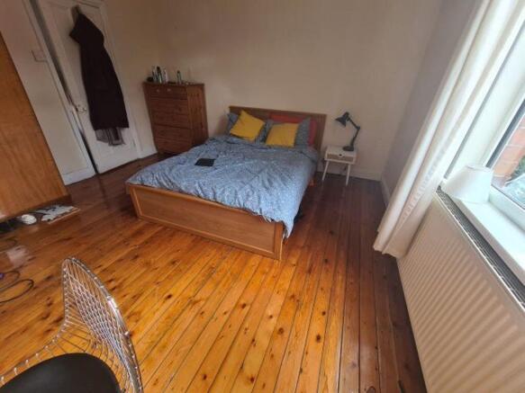 A spacious master bedroom featuring a comfortab...