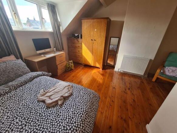 A cozy bedroom featuring a double bed with bedd...