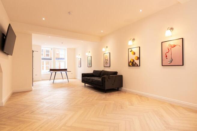 A spacious, well-lit living room featuring a co...