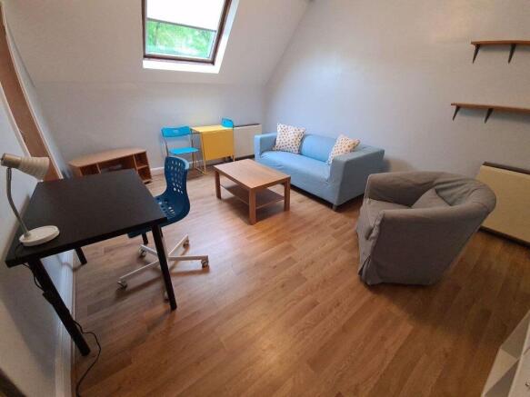 Bright and cozy living room featuring a skyligh...