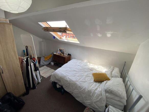Cozy bedroom with a pitched ceiling featuring a...