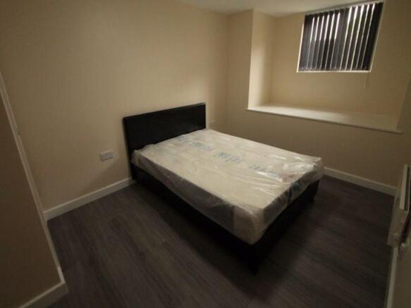 A cozy bedroom featuring a double bed with a ne...