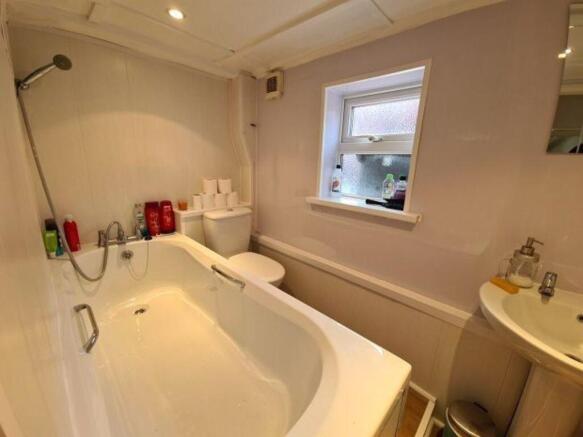Bright and clean bathroom suite featuring a lar...