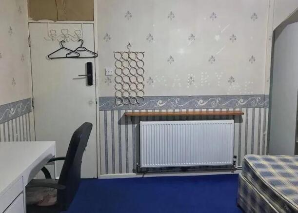 A compact room featuring a simple desk and chai...