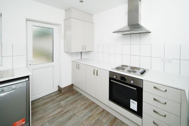 Bright modern kitchen with white cabinets, elec...