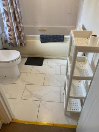 A clean, well-maintained bathroom with white ti...