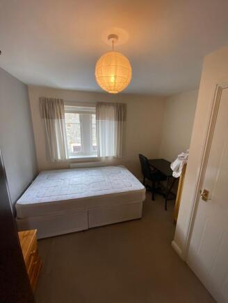 A cozy bedroom featuring a large bed positioned...