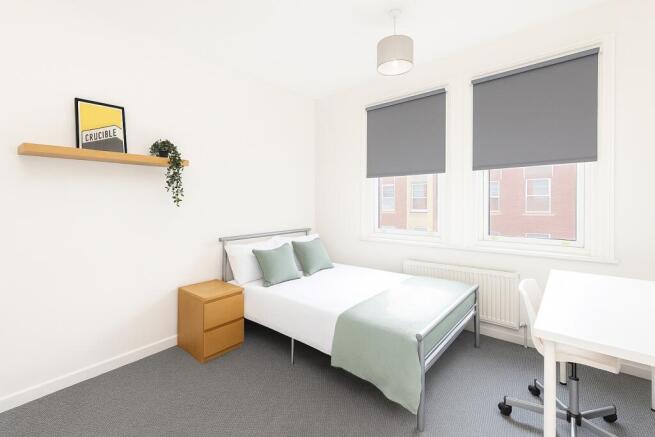 A bright and modern single bedroom featuring a ...
