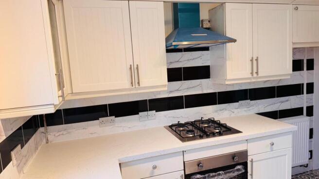 A modern kitchen with a white countertop and bl...