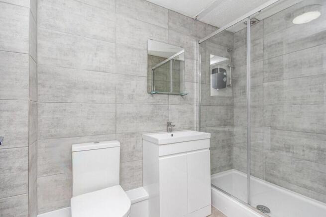 Modern bathroom featuring a walk-in shower with...
