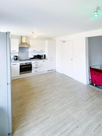 Bright, modern open-plan kitchen with white cab...