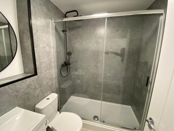 Modern bathroom featuring a spacious shower wit...