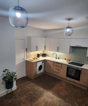 Modern kitchen featuring sleek white and wooden...