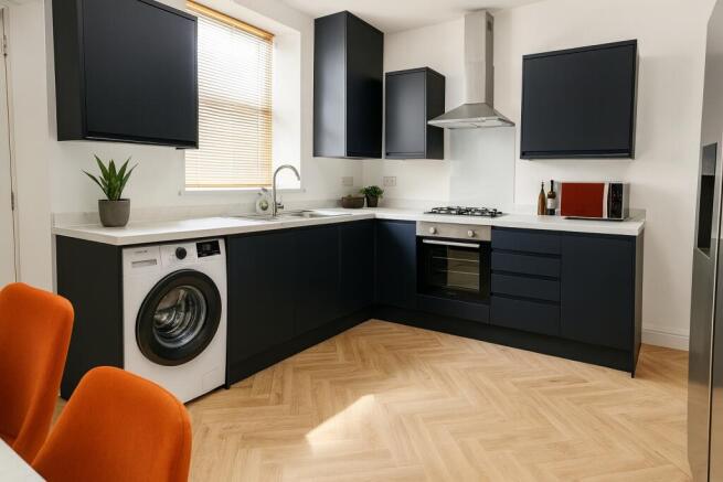 Modern kitchen with sleek navy cabinets, a larg...