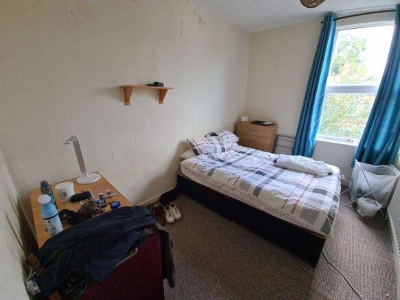 A cozy student bedroom featuring a single bed b...