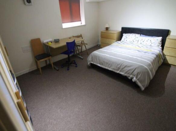 A cozy single bedroom featuring a comfortable b...