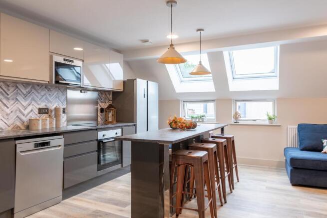 Bright and modern kitchen featuring sleek white...