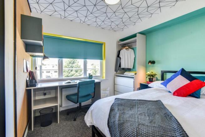 Bright and stylish bedroom featuring a large wi...