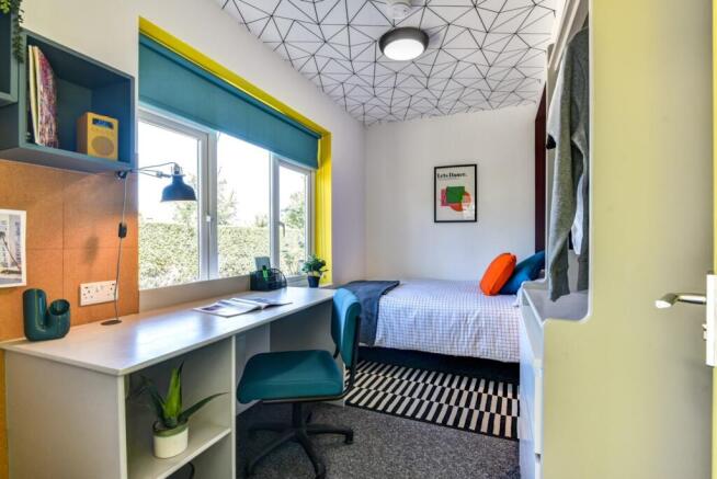 A bright and modern student bedroom featuring a...