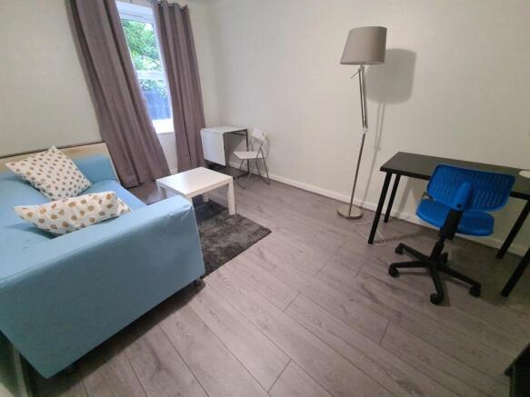 A bright and tidy single bedroom featuring a co...