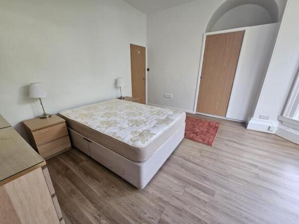 A bright and spacious master bedroom with a lar...