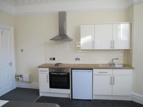 Bright, modern kitchenette with white cabinetry...
