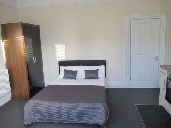Bright, neutrally decorated double bedroom with...