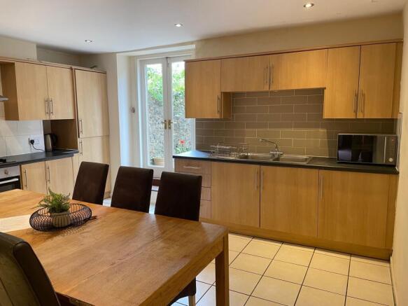 Modern eat-in kitchen with a large wooden dinin...