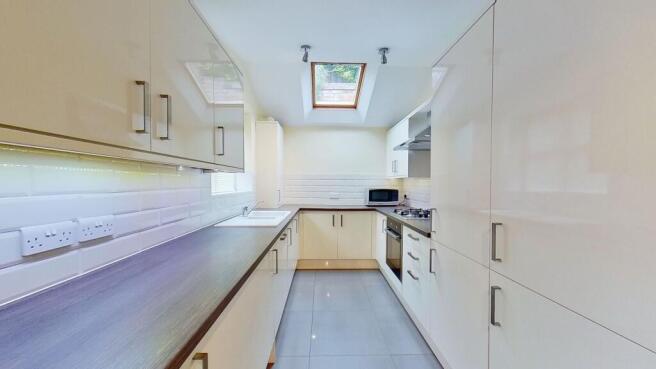 Bright, modern galley kitchen with glossy cream...