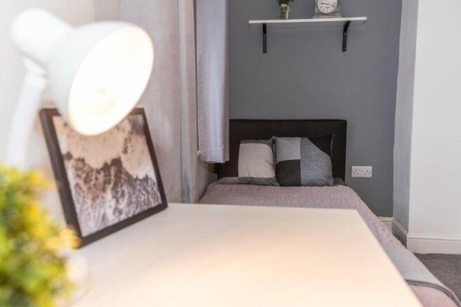 Bright, neatly styled bedroom with a single bed...
