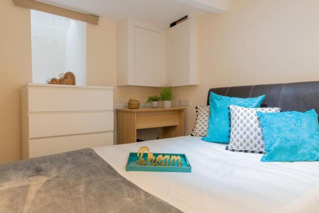 Bright, neatly styled double bedroom with a com...