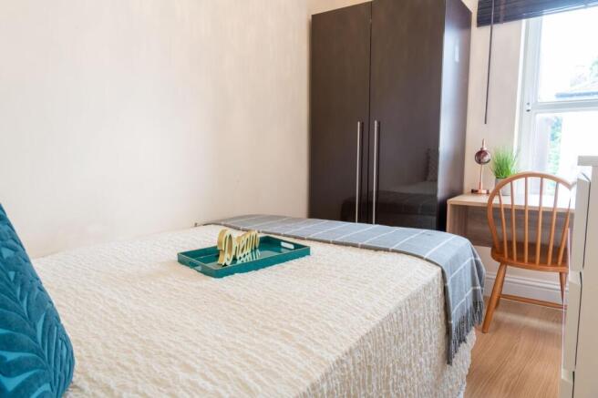 Bright, neatly styled bedroom with a comfortabl...