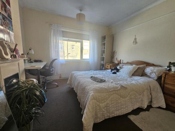 Bright and cozy master bedroom featuring a comf...