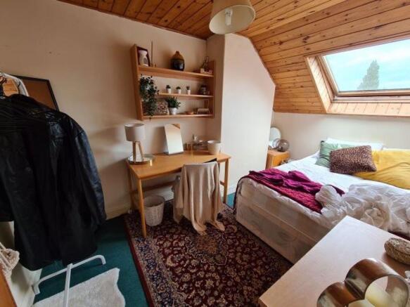 Bright attic master bedroom featuring a cozy do...