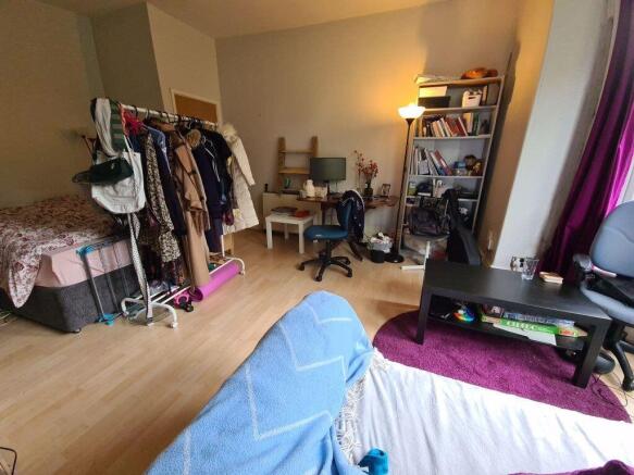 A cozy double bedroom featuring a spacious bed,...