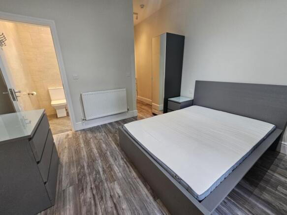 A clean and modern master bedroom featuring a l...