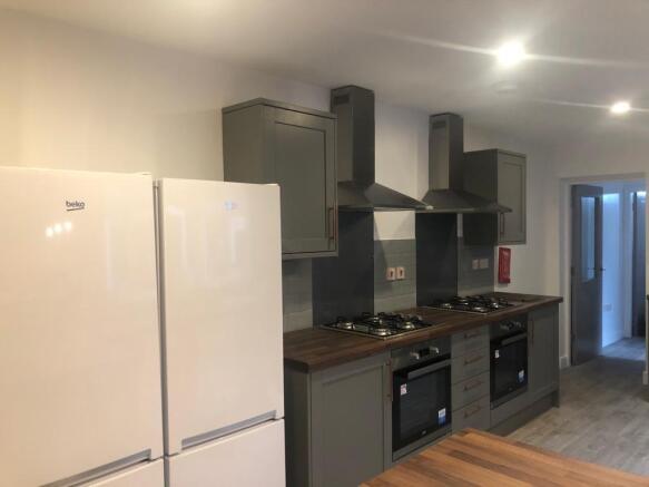 Modern shared kitchen with twin ovens and gas h...