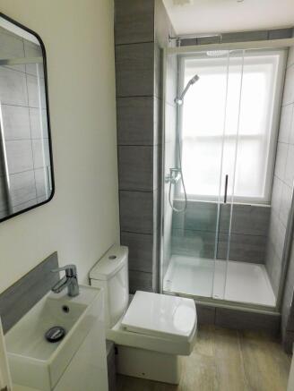 A clean, bright bathroom featuring a shower wit...