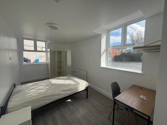 Spacious double bedroom featuring large windows...