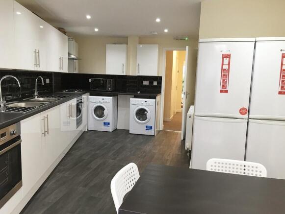 A modern, well-equipped kitchen with sleek whit...