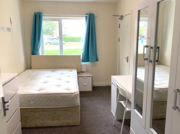 Bright and tidy double bedroom featuring a comf...