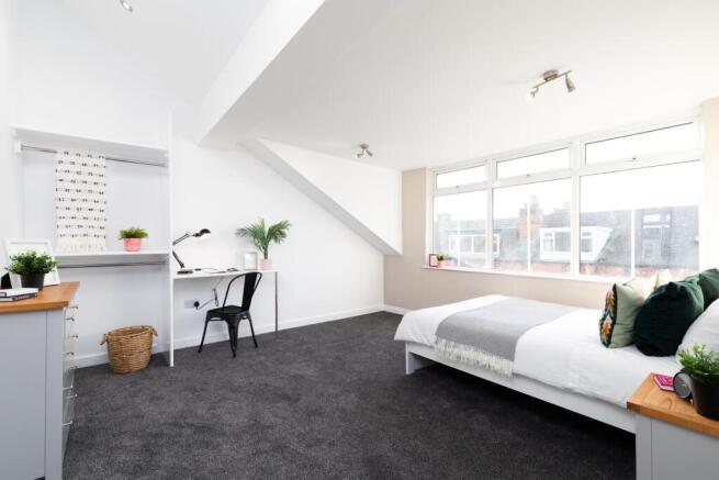 Bright, freshly decorated bedroom with large wi...