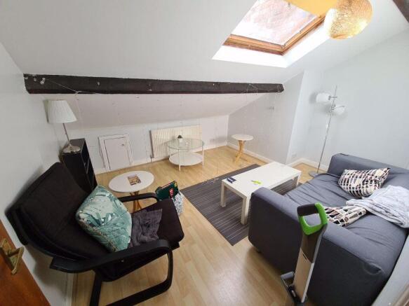 Bright, modern living area with sloped ceiling ...