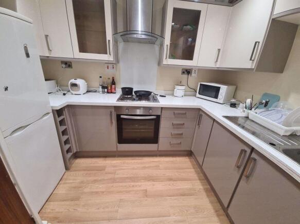 Modern fitted kitchen with integrated oven, hob...