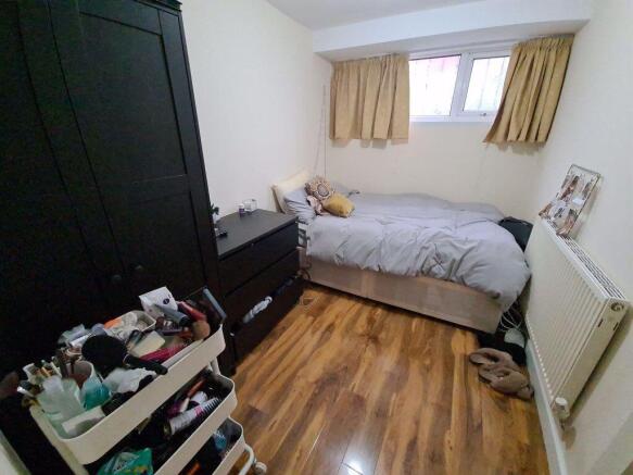 Neat, furnished bedroom with a double bed, fitt...