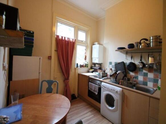 Bright compact kitchen with a round dining tabl...