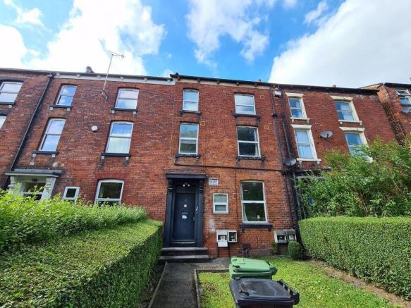 Red-brick terraced house with a neat front gard...